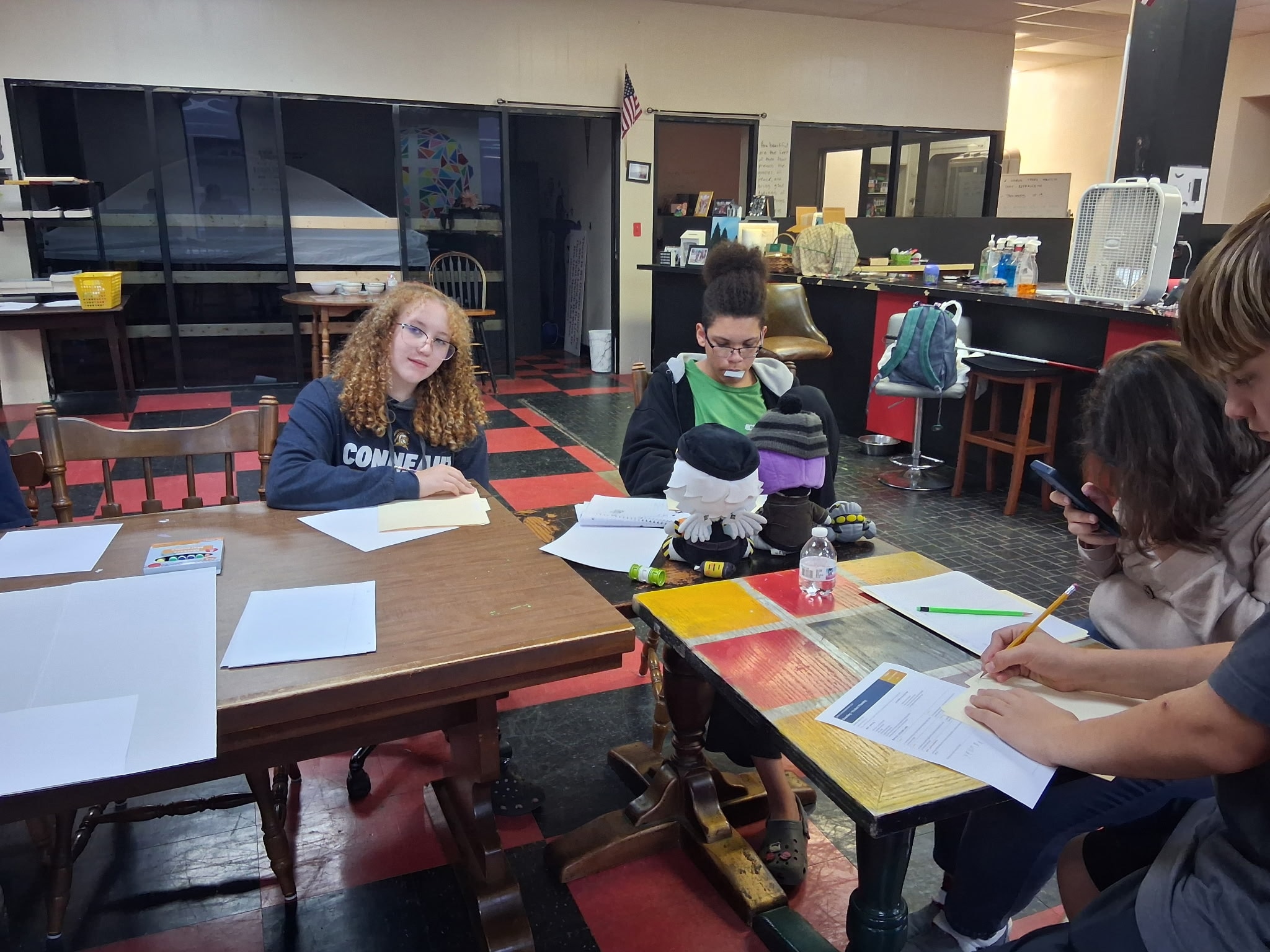 Young entrepreneurs working at tables during the club's first session, sketching product plans and filling out their planning sheets at the Conneaut Youth Center